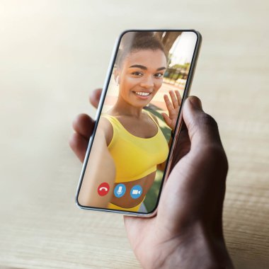 Elinde cep telefonu olan zenci bir arkadaş.