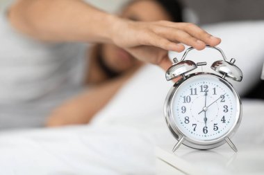 Uyanma zamanı. Yatağın başındaki masada alarma basan adam, kapatıyor.