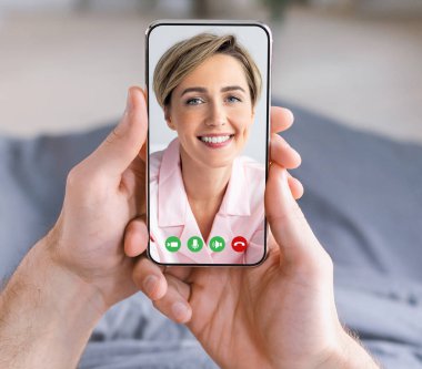 Elinde cep telefonu olan bir adam video görüşmesi yapıyor.
