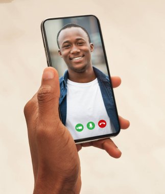 Görüntülü arama. Siyahi bir adam, arkadaşıyla buluşmak için akıllı telefon kullanıyor ya da kardeşiyle telekonferans yapıyor, kolaj yapıyor, yakın plan çekiyor.