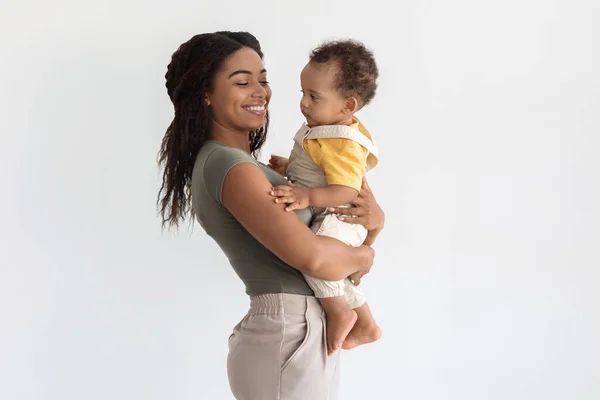 Retrato de familia negra feliz, madre con hijo adorable en las manos — Foto de Stock