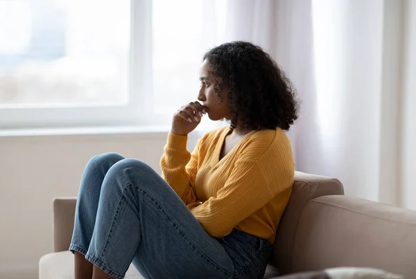 Ψυχιατρική περίθαλψη. Θλιβερή νεαρή μαύρη γυναίκα που υποφέρει από συναισθηματική εξουθένωση στον καναπέ στο σπίτι — Φωτογραφία Αρχείου