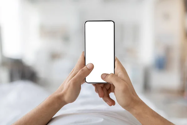 Mockup Mobile. Pria yang Tak Dikenal Memegang Ponsel Pintar Kosong Sambil Relaksasi Di Tempat Tidur — Stok Foto