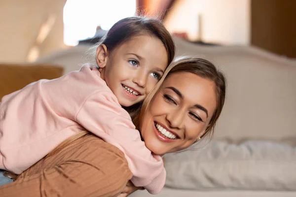 Portret szczęśliwa matka i córka przytulanie w domu — Zdjęcie stockowe