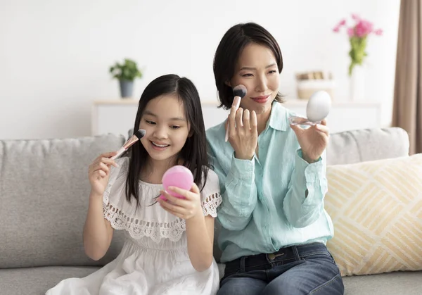 Felice donna asiatica matura con la sua nipotina carina applicare il trucco, divertirsi a casa — Foto Stock