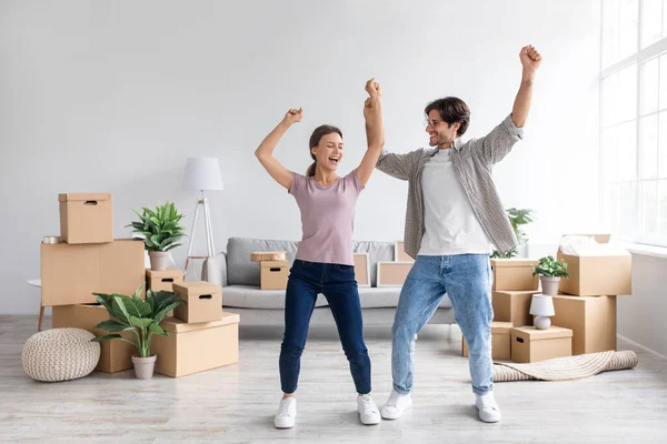 Feliz hombre milenario europeo y señora bailando en el interior de la sala de estar con cajas de cartón — Foto de Stock