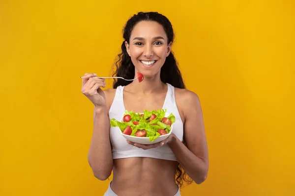 Retrato de sorridente latina senhora segurando prato com salada — Fotografia de Stock