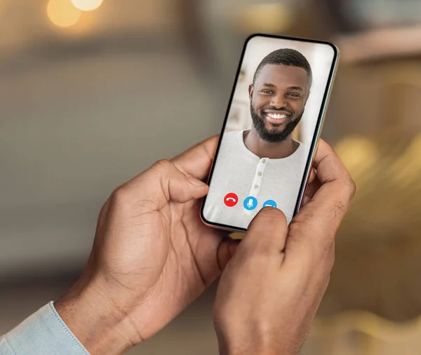 Hombre negro sosteniendo el teléfono celular en la mano video llamadas amigo distancia — Foto de Stock