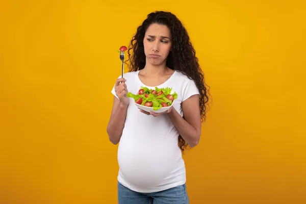 Portrét smutné těhotné dámy držící talíř se zeleninovým salátem — Stock fotografie