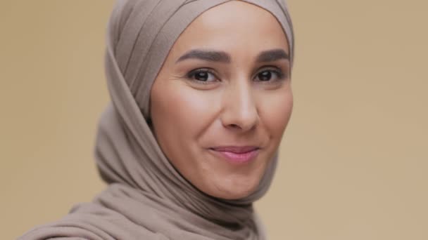 Un estilo de vida positivo. Primer plano retrato de la joven dama musulmana feliz usando hijab sonriendo ampliamente a la cámara, espacio vacío — Vídeos de Stock