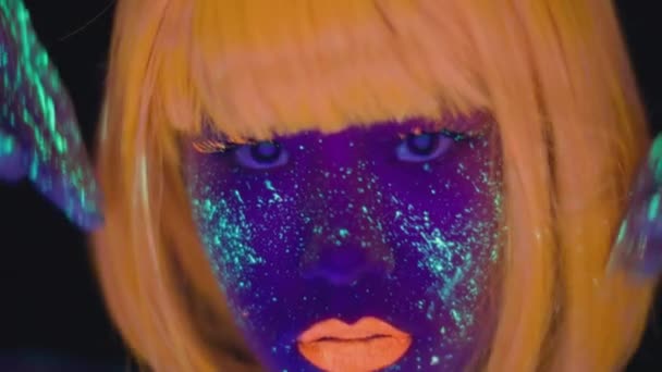 Close up portrait of young stylish asian woman pj with glowing make up and body art wearing orange wig dancing to camera — Stock Video