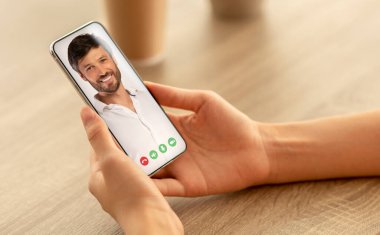 Elinde cep telefonu olan bir kadın video görüşmesi yapıyor.