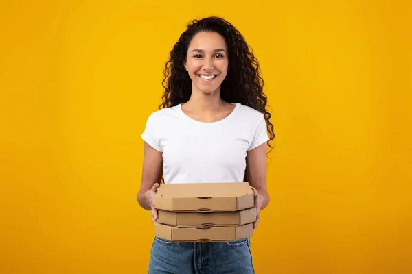 Feliz señora latina sosteniendo cajas de pizza en el estudio —  Fotos de Stock