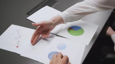 İş analizleri. Tanımlanamayan meslektaşlar veya ortaklar pazarlama stratejisini grafik ve grafiklerle tartışıyor