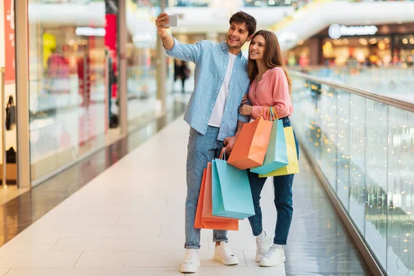 Szczęśliwa para Zakupy i zrobienie Selfie na telefon w centrum handlowym — Zdjęcie stockowe