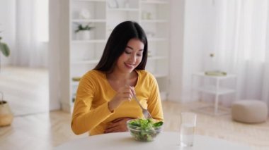 Hamilelik diyeti. Mutlu Asyalı Kadın Evde Taze Sebze Yiyiyor