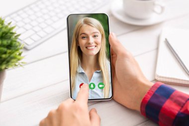 Elinde cep telefonu olan bir adam kız arkadaşını arıyor.