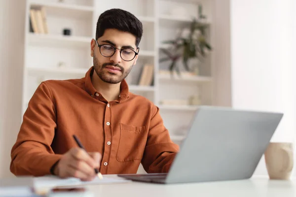 Konzentrierter arabischer Mann mit Brille und Laptop — Stockfoto