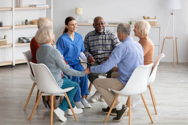 Positive junge Psychologin bei Gruppentherapie mit Senioren — Stockfoto