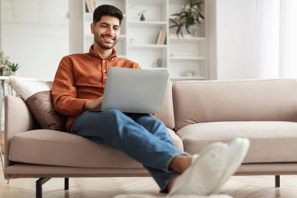 Porträt eines lächelnden arabischen Mannes, der zu Hause den PC benutzt — Stockfoto
