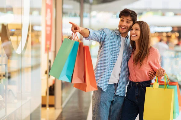 Pareja de compras juntos, marido señalando dedo en la tienda en el centro comercial —  Fotos de Stock