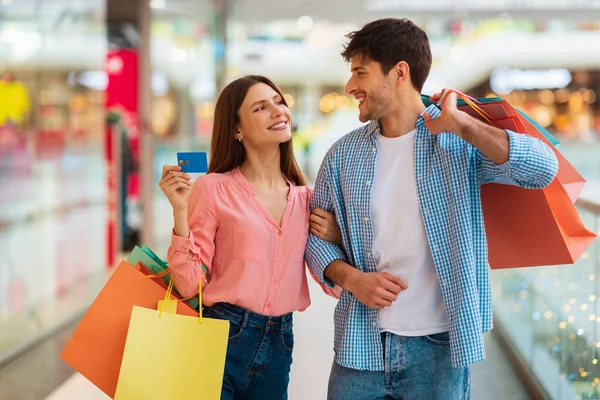 Para robi zakupy z kartą kredytową i torbami w hipermarkecie — Zdjęcie stockowe