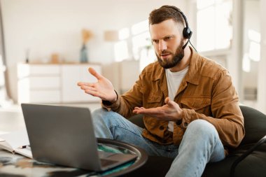 Erkek Freelancer evdeki bilgisayarla video görüşmesi yapıyor.