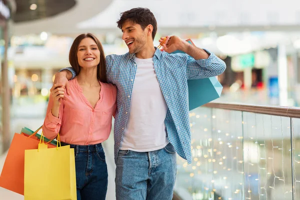Happy para przytulanie robi zakupy spaceru razem w hipermarkecie — Zdjęcie stockowe