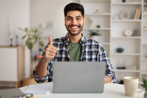 Retrato de hombre árabe sonriente usando laptop mostrando pulgares hacia arriba —  Fotos de Stock
