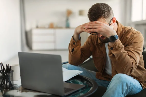 Стресс человек на ноутбуке трогательная голова, имеющие проблемы с бизнесом в помещении — стоковое фото