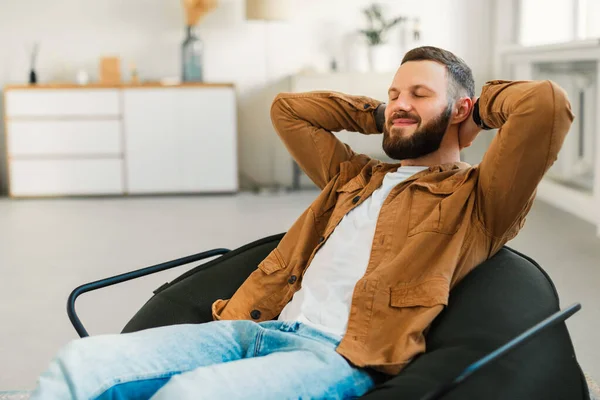 Relaxado barbudo homem descansando com os olhos fechados sentado em casa — Fotografia de Stock