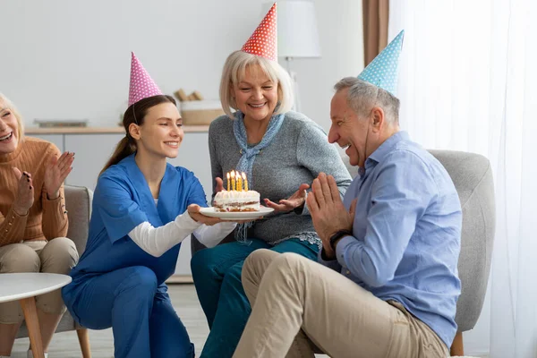 Veselí starší přátelé slaví narozeniny v domově důchodců — Stock fotografie