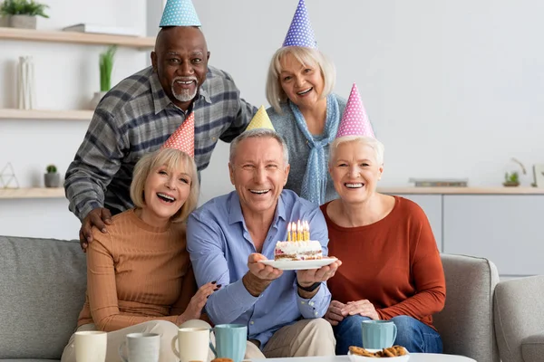 Международная группа пожилых людей, празднующих день рождения дома — стоковое фото