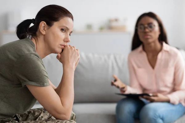 Psychotherapy Concept. Young military woman having therapy meeting with black female psychologist