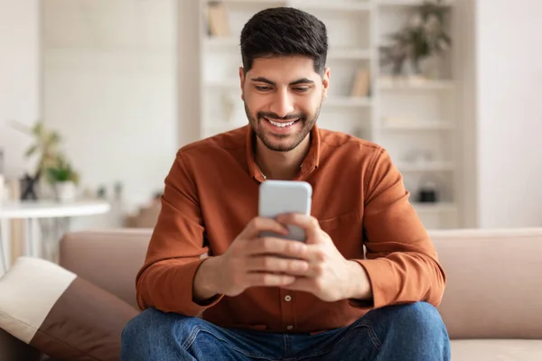 집에서 스마트 폰을 사용하여 아랍 남자웃는 사진 — 스톡 사진