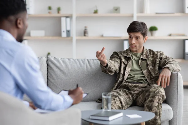 Rude military guy showing his psychologist inappropriate gesture