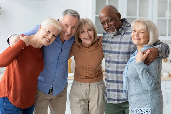 Foto de grupo de pessoas idosas felizes abraçando, sorrindo para a câmera — Fotografia de Stock