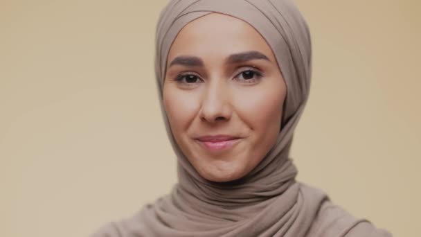 Retrato de cerca de la joven dama musulmana feliz en el pañuelo de cabeza tradicional sonriendo ampliamente a la cámara, mostrando una sonrisa perfecta — Vídeos de Stock