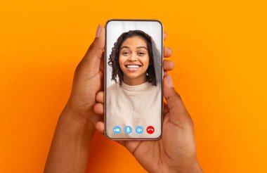 Elinde cep telefonu olan siyahi bir kadın. Görüntülü arıyor.