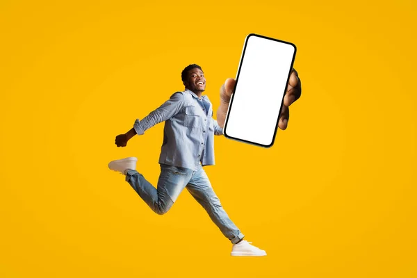 점프하는 남자 손에 빈 화면 이 있는 새로운 스마트폰 — 스톡 사진