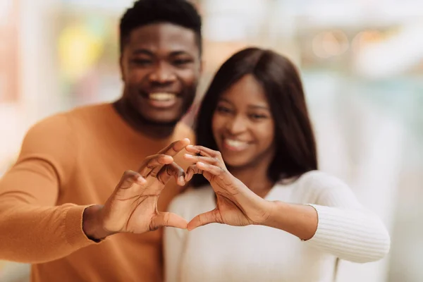 Heureux couple noir souriant en forme de coeur avec les mains — Photo