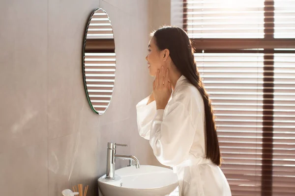 Zijaanzicht van aantrekkelijke Koreaanse dame aanraken van haar gezicht — Stockfoto