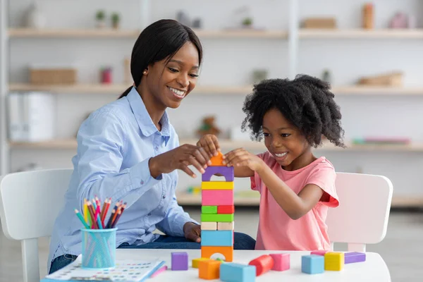 Schattige zwarte kind en kind ontwikkeling specialist spelen met stenen — Stockfoto