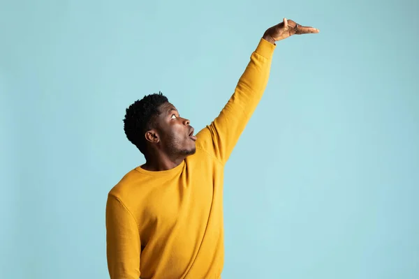 Amazed afro-americano uomo mostrando altezza di qualcosa — Foto Stock