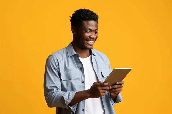 Feliz afroamericano chico sosteniendo tableta digital y sonriendo —  Fotos de Stock