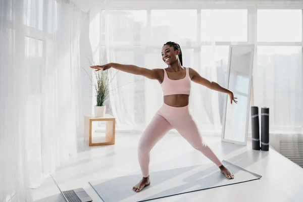 Genç Afrikalı Amerikalı kadın yoga yapıyor, ev içi spor yapıyor, spor salonunda online video çekiyor. — Stok fotoğraf