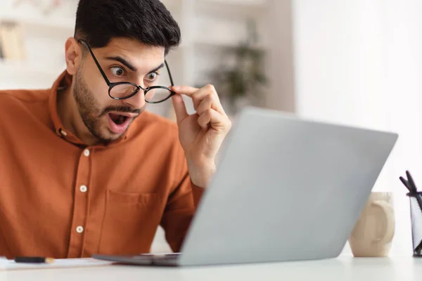 Zavarodott arab fickó laptoppal nézi a képernyőt — Stock Fotó
