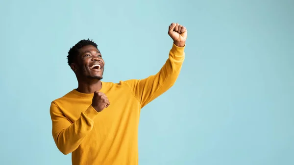 Emotional african american guy raising fists up, copy space, panorama — Stock Photo, Image