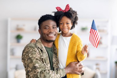 Mutlu siyah asker baba ve kızı Amerikan bayrağıyla portresi
