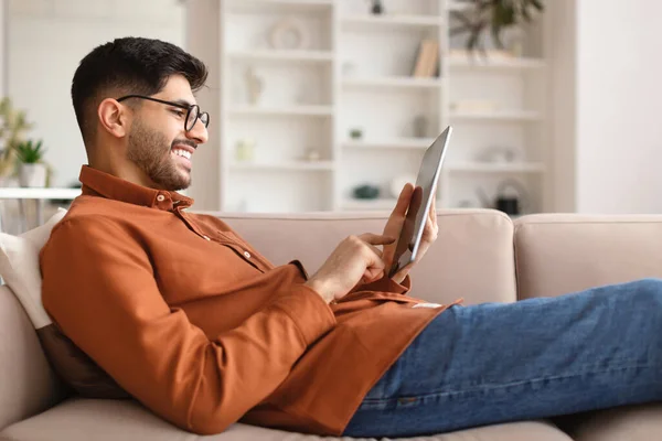 Sorrindo jovem árabe usando tablet digital em casa — Fotografia de Stock